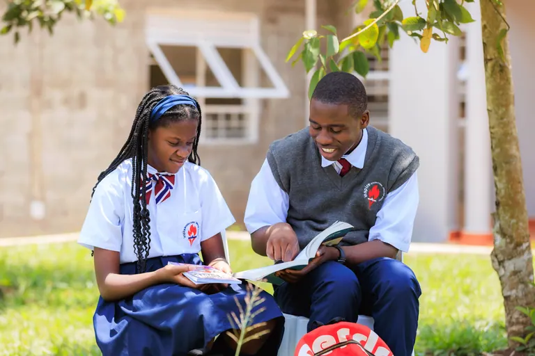 Learners reading together on the school grounds