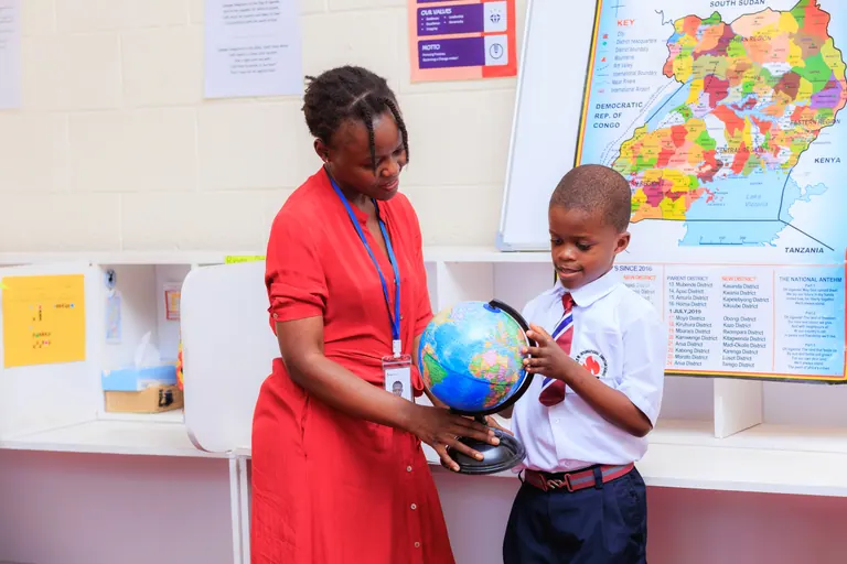 An educator helping a learner explore a globe