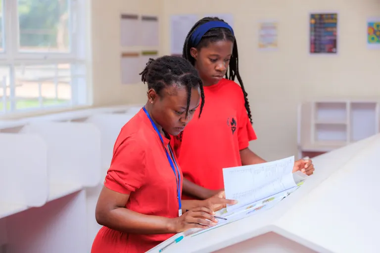 An educator and learner reviewing a workbook together