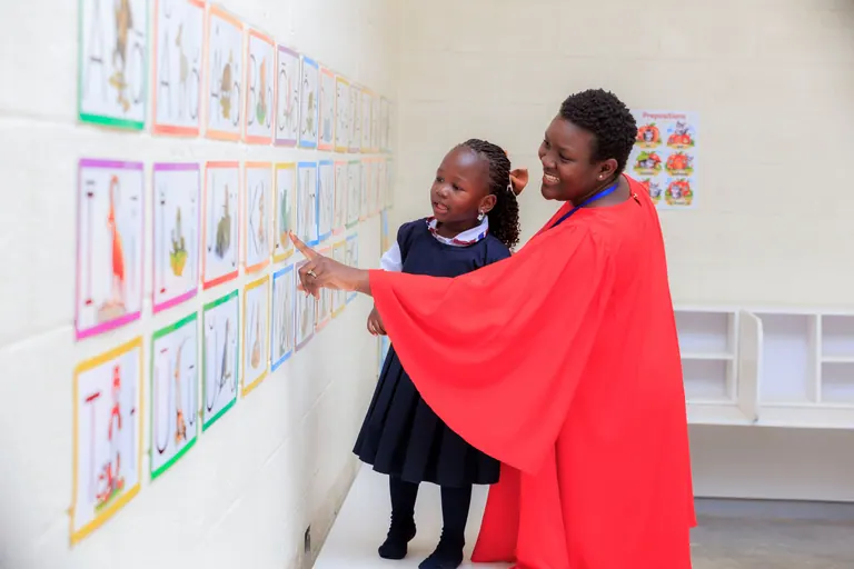 An educator and learner exploring an alphabet display